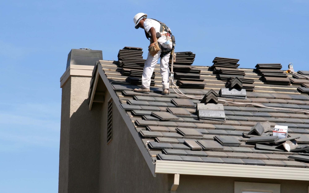 Side view of a roofing worker laying out tiles