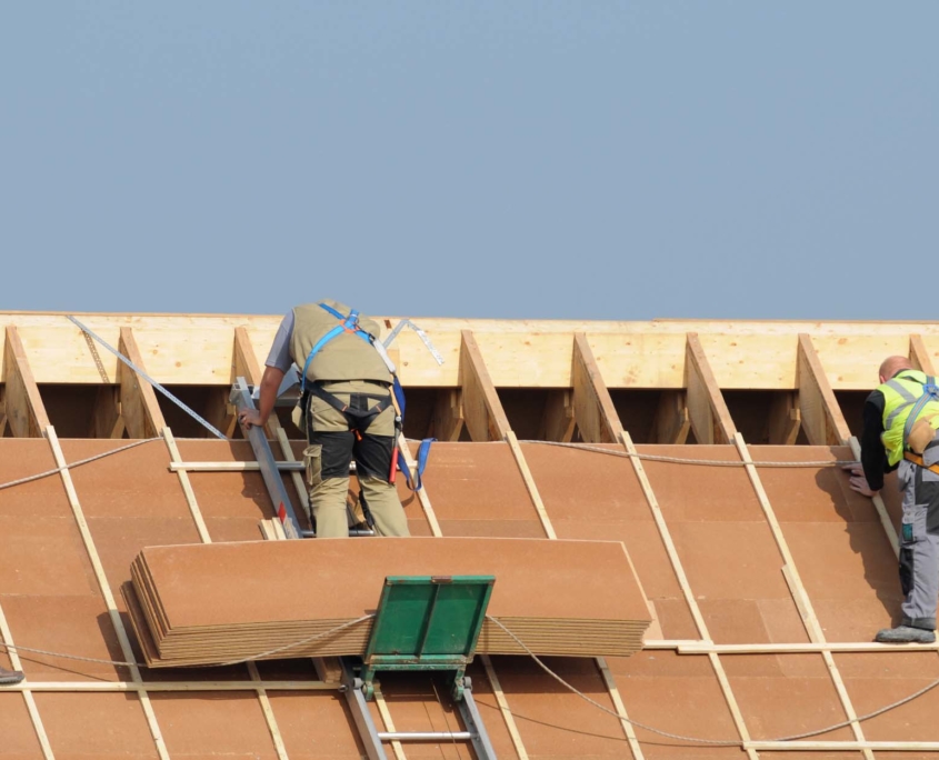 View of residential roofers working on new roof deck